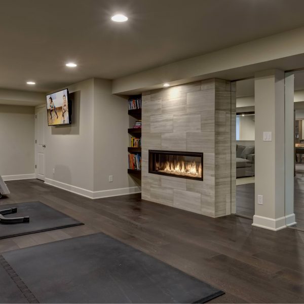remodeled basement exercise room with fireplace