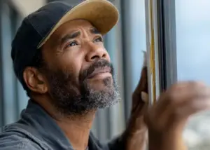 handyman inspecting weatherstripping on a window