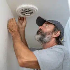 Handyman fixing a bathroom exhaust fan